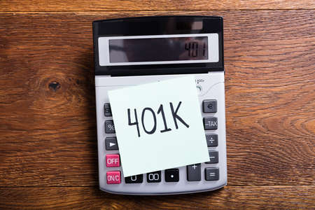 High Angle View Of A Budget Of 401k In Calculator At Wooden Deskの写真素材