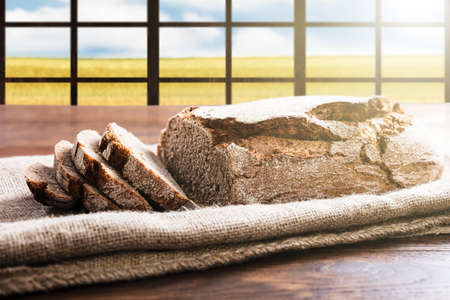 Close-up Of A Sliced Bread On A Sack At Wooden Desk Near Windowの写真素材
