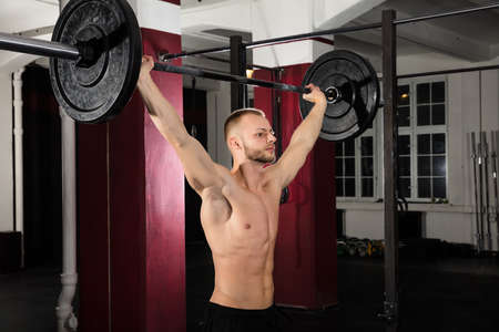 Young Athlete Man Working Out With Barbell In The Gymの写真素材