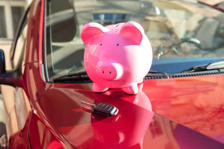 Close-up Of A Piggybank With Car Key On New Red Carの写真素材