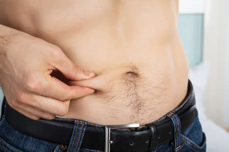 Close-up Of A Person Measuring Fat On Belly