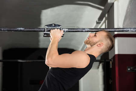 Close-up Of An Athlete Man Doing Narrow Grip Pullup Exercise In The Gym