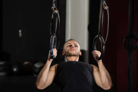 Fitness Man Exercising On Gymnastic Rings In The Gymの写真素材