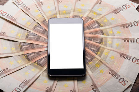High Angle View Of A Mobile Phone Showing Blank Screen On Euro Notes