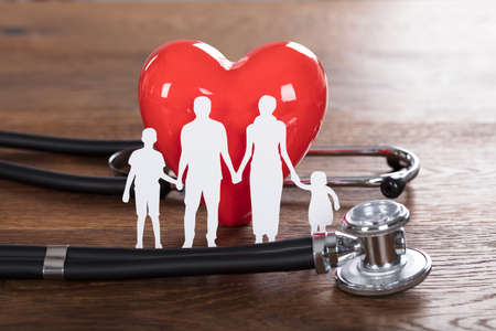 Medical Insurance Concept With Family Cut-out And Stethoscope On Wooden Deskの写真素材