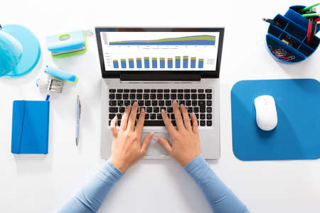 Close-up Of A Businesswoman Analyzing Graph On Laptop At Workplace