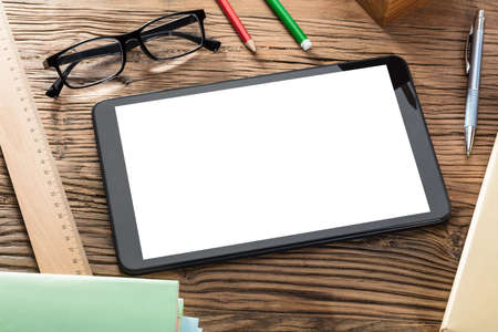 Blank Screen Digital Tablet On Wooden Table With Office Suppliesの写真素材