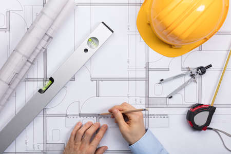 High Angle View Of Architect Hands Working On Blueprintの写真素材