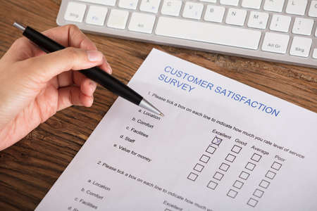 Cross Placed In Excellent Checkbox On Customer Satisfaction Survey Form By A Businesspersonの写真素材