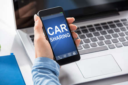 Close-up Of A Woman Using Car Sharing Service On Smart Phoneの写真素材