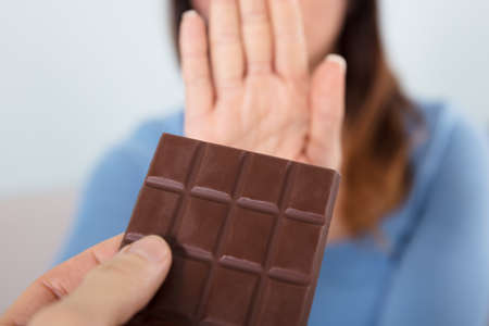 Close-up Of A Woman Rejecting Chocolate Barの写真素材