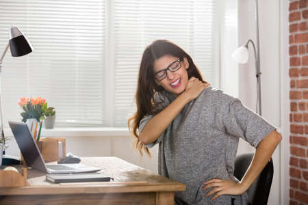 Young Attractive Businesswoman Having Neck Pain In Officeの写真素材
