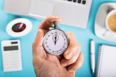 Close-up Of A Person Stopping A Stopwatch In Officeの写真素材