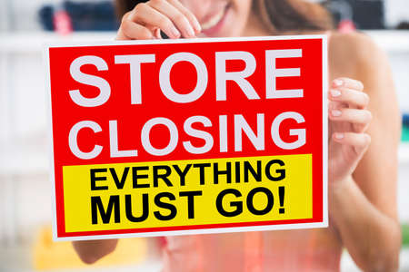 Close-up Of A Woman Sticking Closed Sign On Shop Doorの写真素材