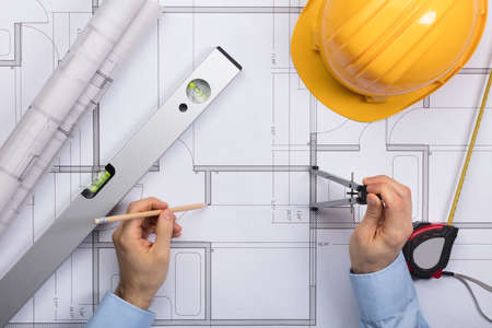 High Angle View Of Architect Hands Working On Blueprintの写真素材