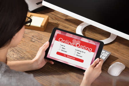 Woman Using Online Dating Website On A Digital Tabletの写真素材