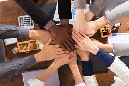 Businesspeople Putting Their Hands On Top Of Each Other At Conference