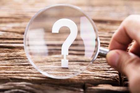 A Person Looking At Question Mark Sign Through Magnifying Glassの写真素材