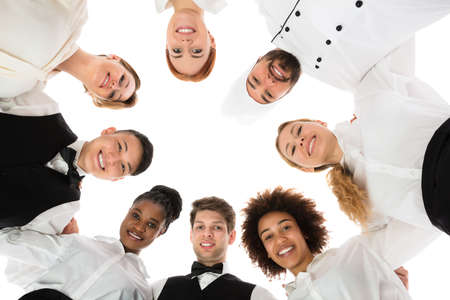Low Angle View Of Happy Restaurant Staff Forming Huddleの写真素材