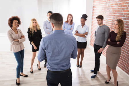 Rear View Of Manager Having Conversation With His Business Colleagues In The Officeの写真素材
