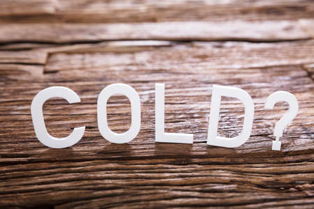 Close-up Of A Cold Text With Question Mark Sign On Wooden Backgroundの写真素材