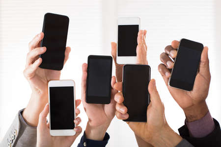 Businesspeople Showing Their Smart Phone On White Backgroundの写真素材