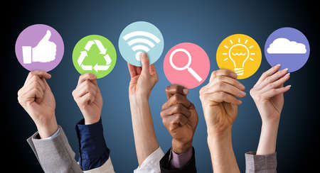 Businesspeople Hands Holding Various Business Symbols Against The Blue Background
