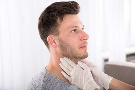 Doctor Performing Physical Exam Palpation Of The Thyroid Gland