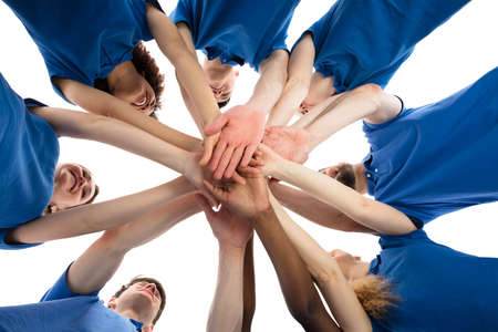 Low Angle View Of Smiling Multiracial Janitors Stacking Hands
