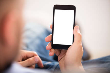 Close-up Of A Man's Hand Holding Cell Phone With White Blank Screen