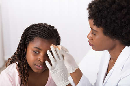 Close-up Of A Doctor Applying Plastic Aid To Girl Head In Clinic