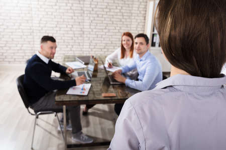 Rear View Of A Businesswoman Giving Presentation To Her Colleagues In Officeの写真素材