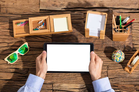 Business Person Holding Digital Tablet With Blank Screen Over The Office Deskの写真素材