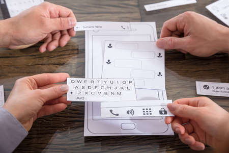 Hands Of Business People Discussing UX Mockups