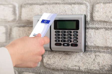 A Person's Hand Holding Access Card To Lock And Unlock Door