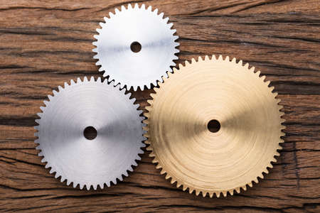 Closeup photo of three interlocking metal gearsの写真素材