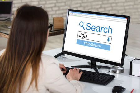 Rear View Of A Businesswoman Searching Online Job On Computer In Officeの写真素材