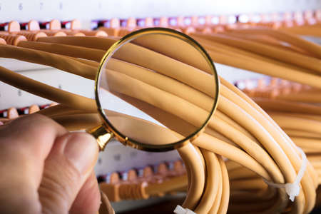 Cropped image of hand examining network cables in server room