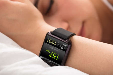 Smart Watch Showing Heartbeat Rate On Sleeping Woman's Handの写真素材