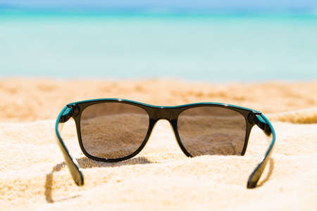 Black Sunglasses On Sand At Beach In Summerの写真素材