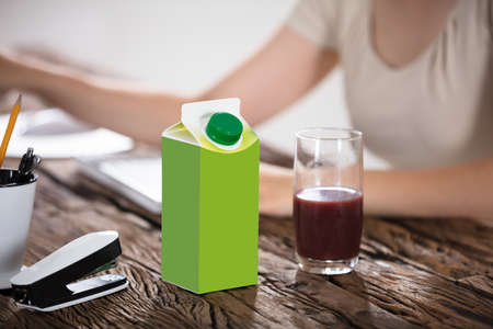 Juice Package And Juice Glass On Wooden Tableの写真素材