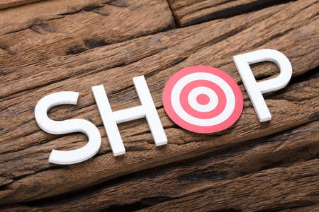 High angle view of shop text with dartboard on wooden tableの写真素材