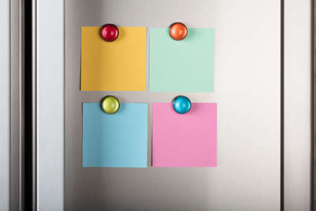 Closeup of blank notes attached with colorful magnetic thumbtacks on metalの写真素材