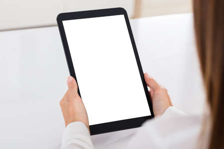 Human Hand Holding Digital Tablet With Blank White Screenの写真素材