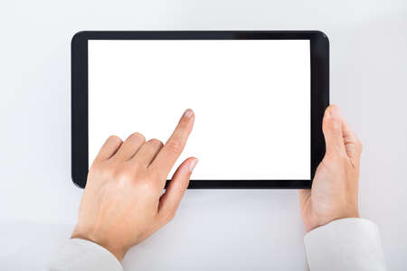 High Angle View Of A Businessperson Using Digital Tablet With Blank White Screenの写真素材