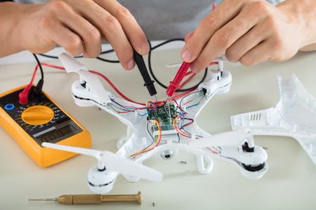 Close-up Of A Man Testing Electric Current Of Disassembled Drone Using Multimeter Toolのeditorial素材