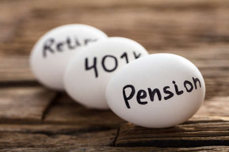 Closeup of pension  401K and retire written on white eggsの写真素材