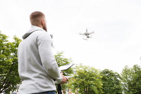 Man Operating The Quadrocopter In The Parkのeditorial素材