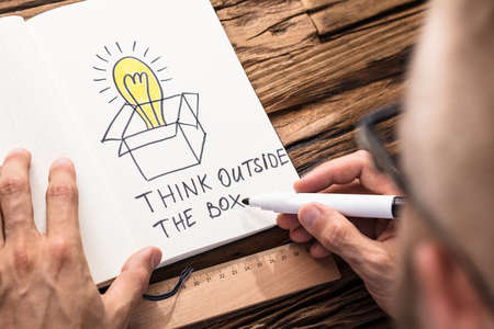 Businessman Drawing The Think Outside The Box Concept Chart On Notebook With Black Markerの写真素材