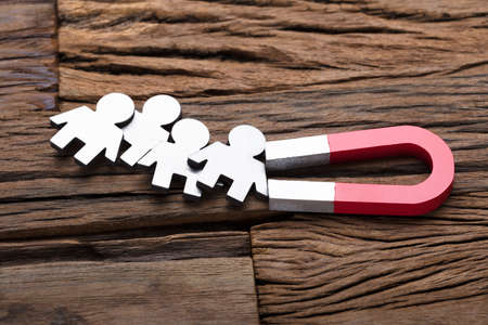 High angle view of magnet attracting traffic on wooden tableの写真素材